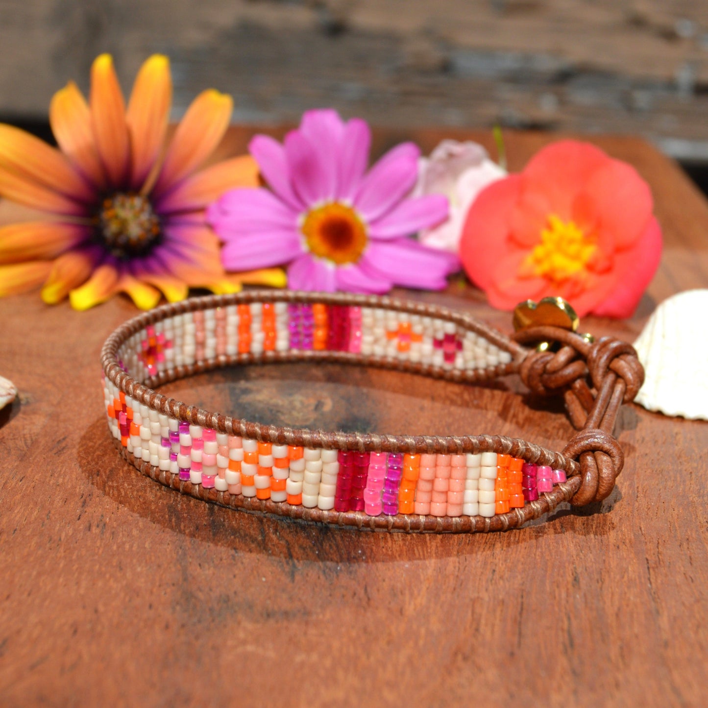 Woven bracelet made of Japanese seed beads of high quality wrapped on leather thread. Metal button in gold colour with flower design.