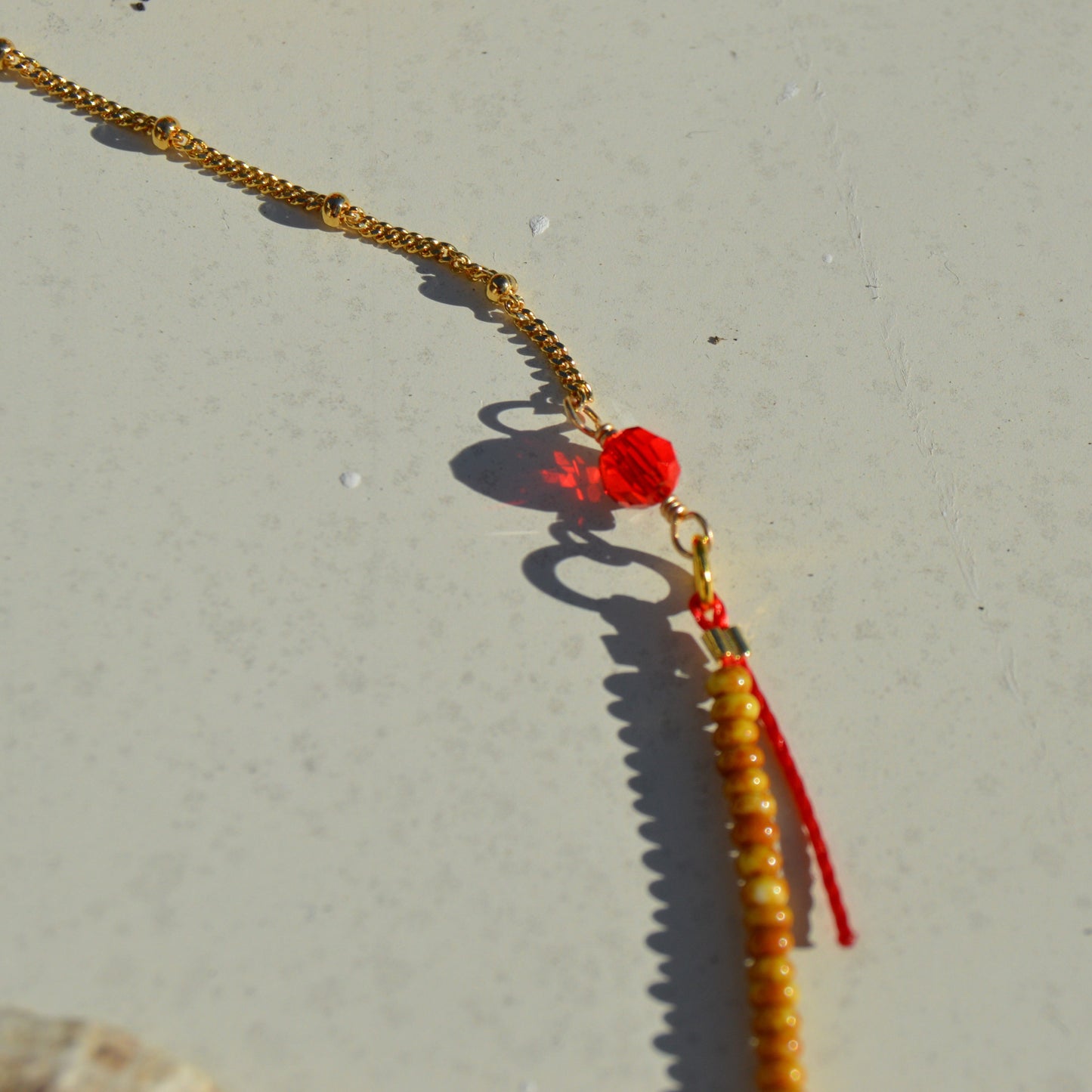 Bohemian, nature-inspired necklace in red and orange shade attached to a delicate gold-plated sterling silver chain. With sun charm and red and orange faceted Czech glass crystals.