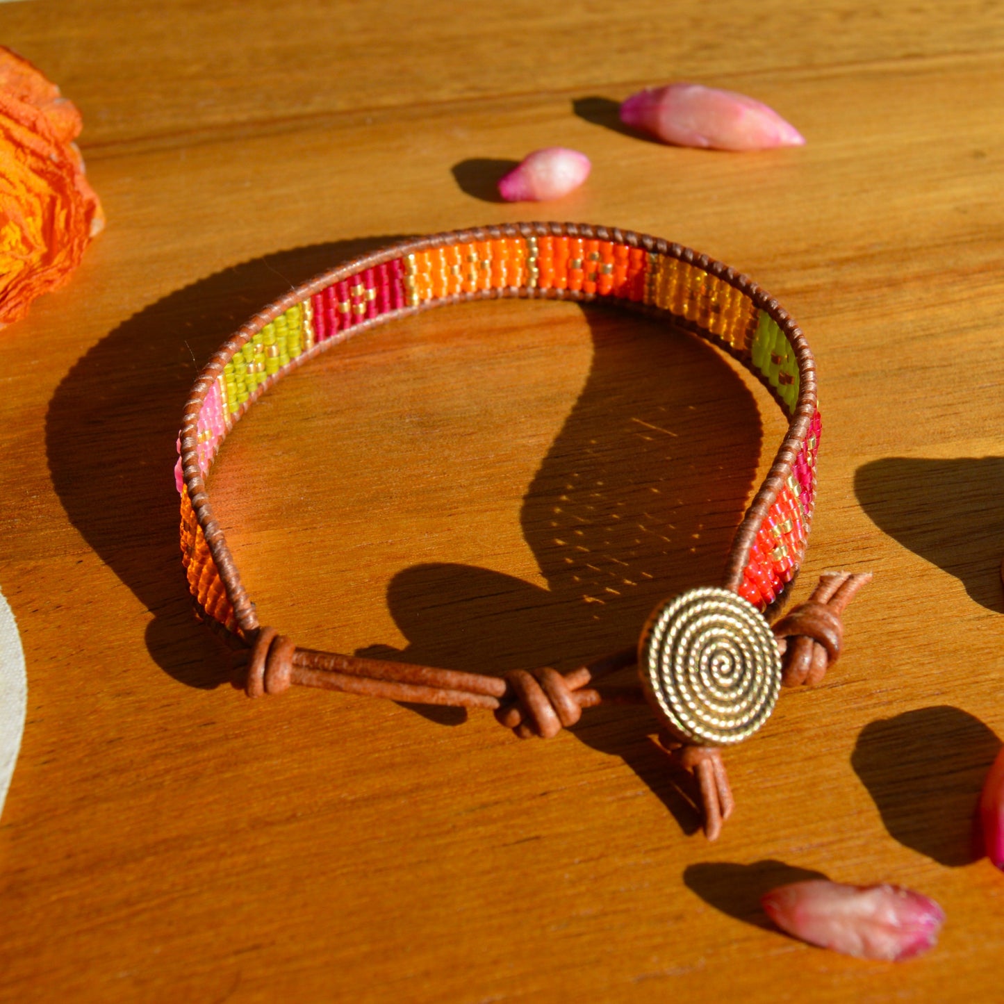 Beaded leather wrap bracelet with gold-coloured button as a lock. Extension in leather.