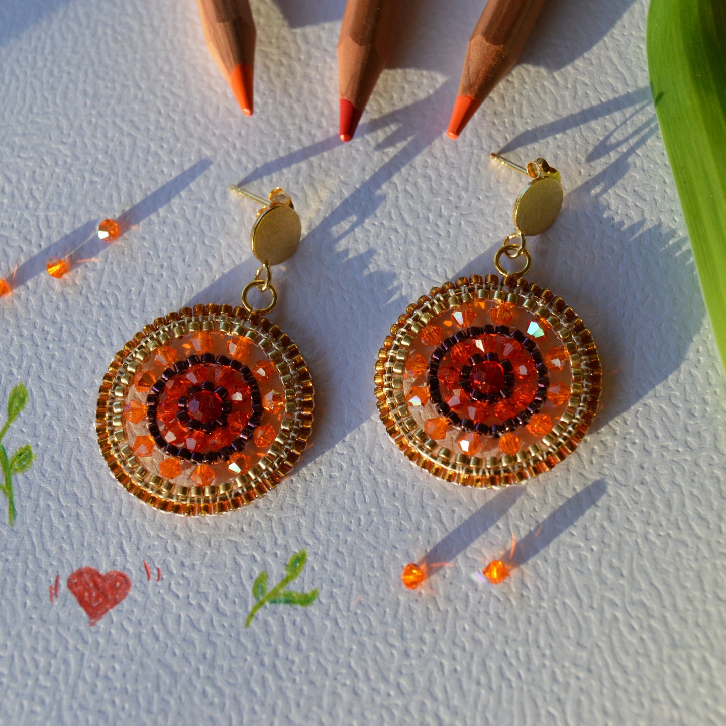 Colorful gold-plated sterling silver woven hoops with ear studs.