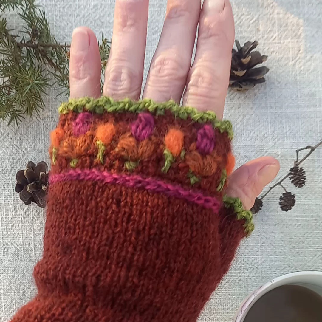 Folklore pulse warmers in red brown and crochet flowers. 