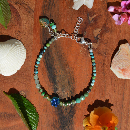 Sterling silver gemstone bracelet with Czech glass flower in the center. Blue Lagon.
