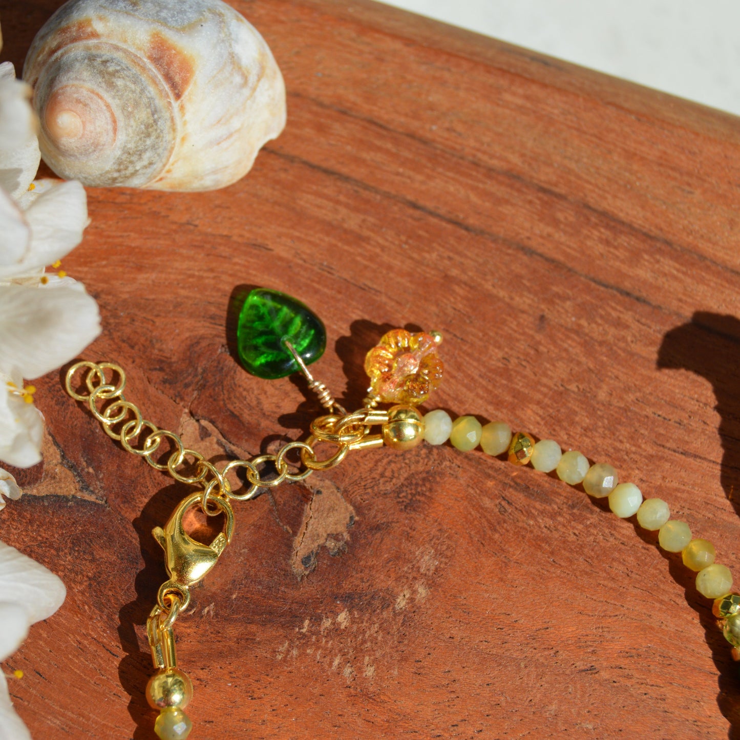 Gold-plated sterling silver gemstone bracelet featuring yellow opal, olivine, malachite, amazonite, turquoise, jasper, and hematite. Czech glass bead flowers and leaf as a decoration. Extension chain.