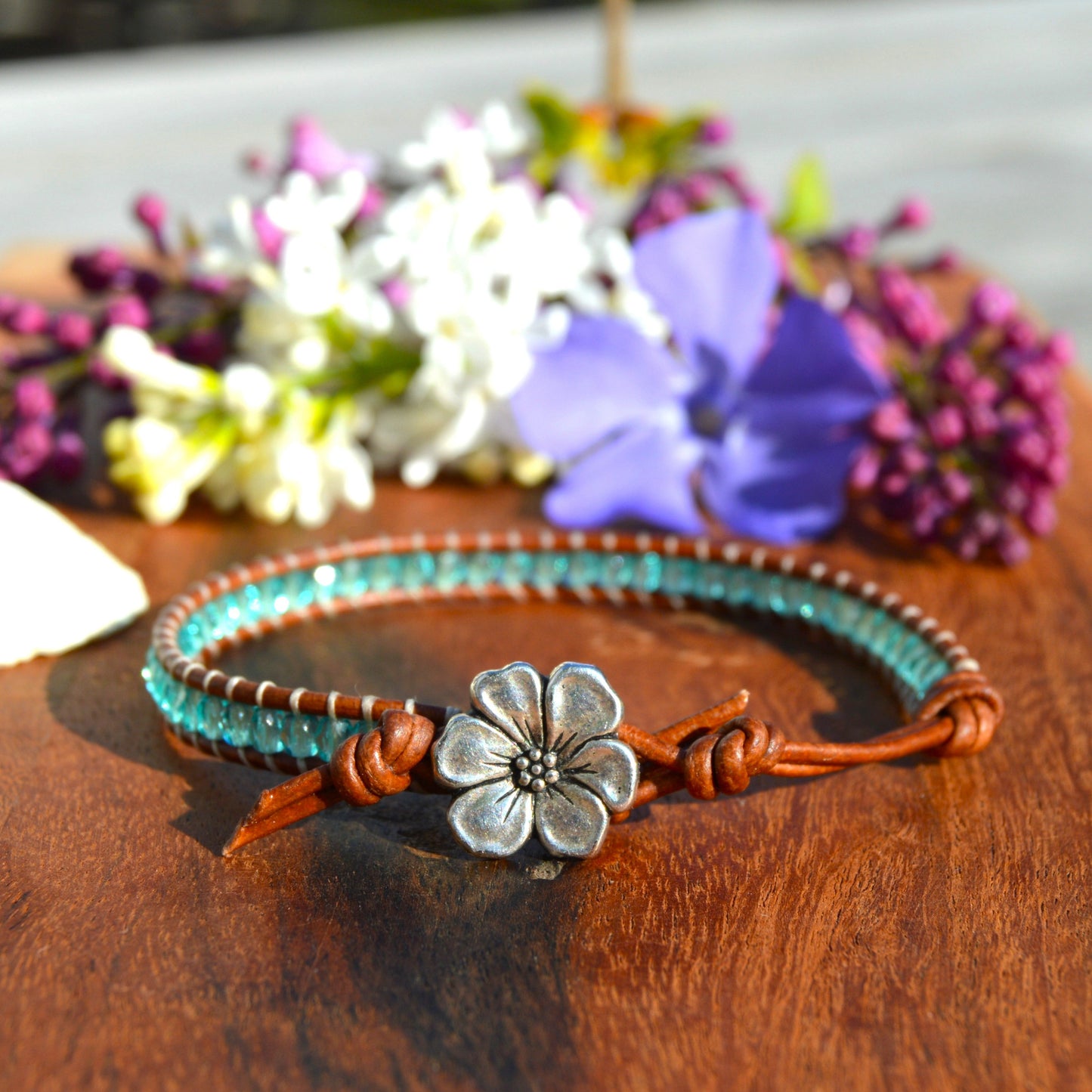 Leather wrap bracelet with Czech glass beads in light turquoise with flower button as a lock.