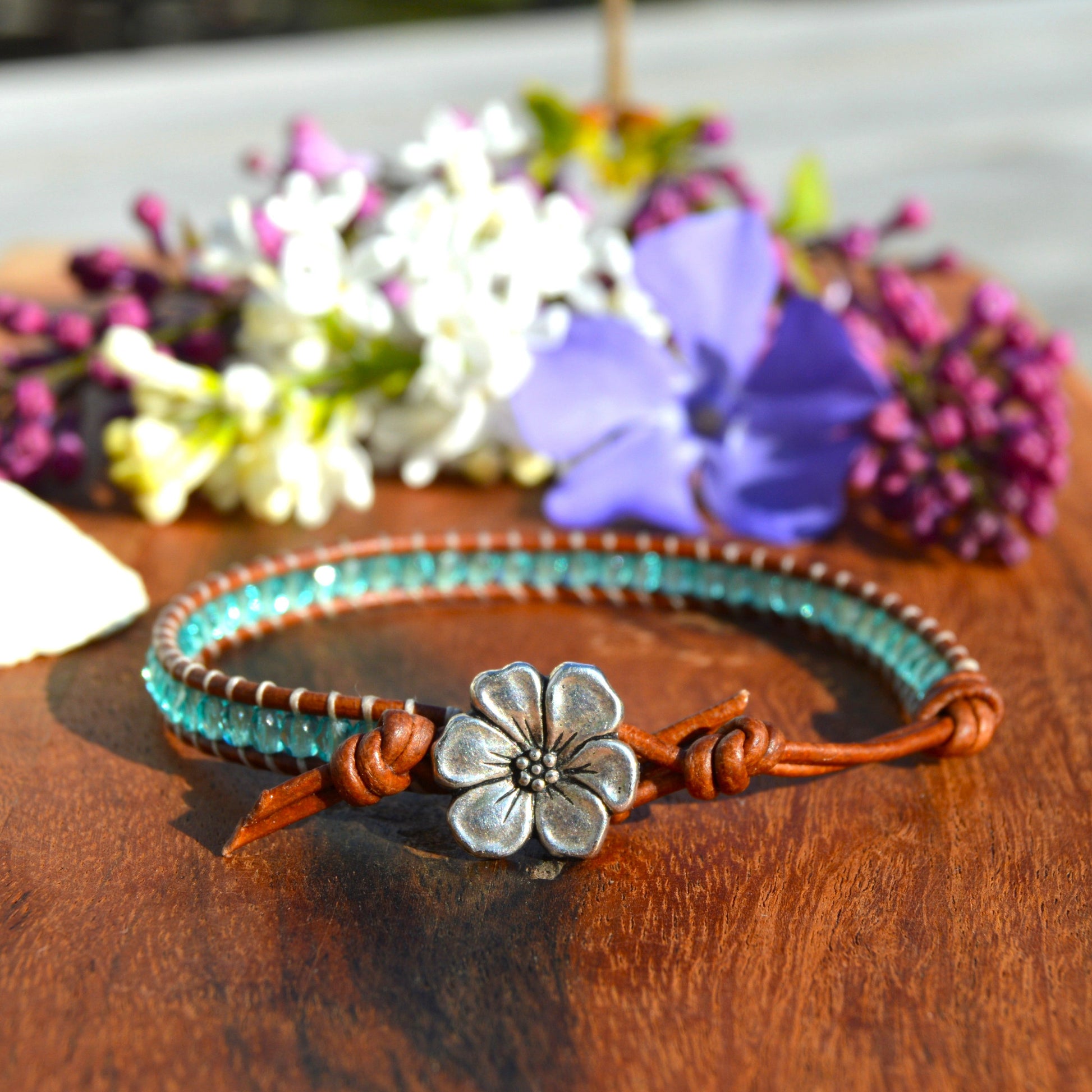 Leather wrap bracelet with Czech glass beads in light turquoise with flower button as a lock.
