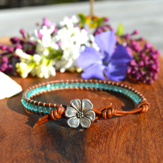 Leather wrap bracelet with Czech glass beads in light turquoise with flower button as a lock.