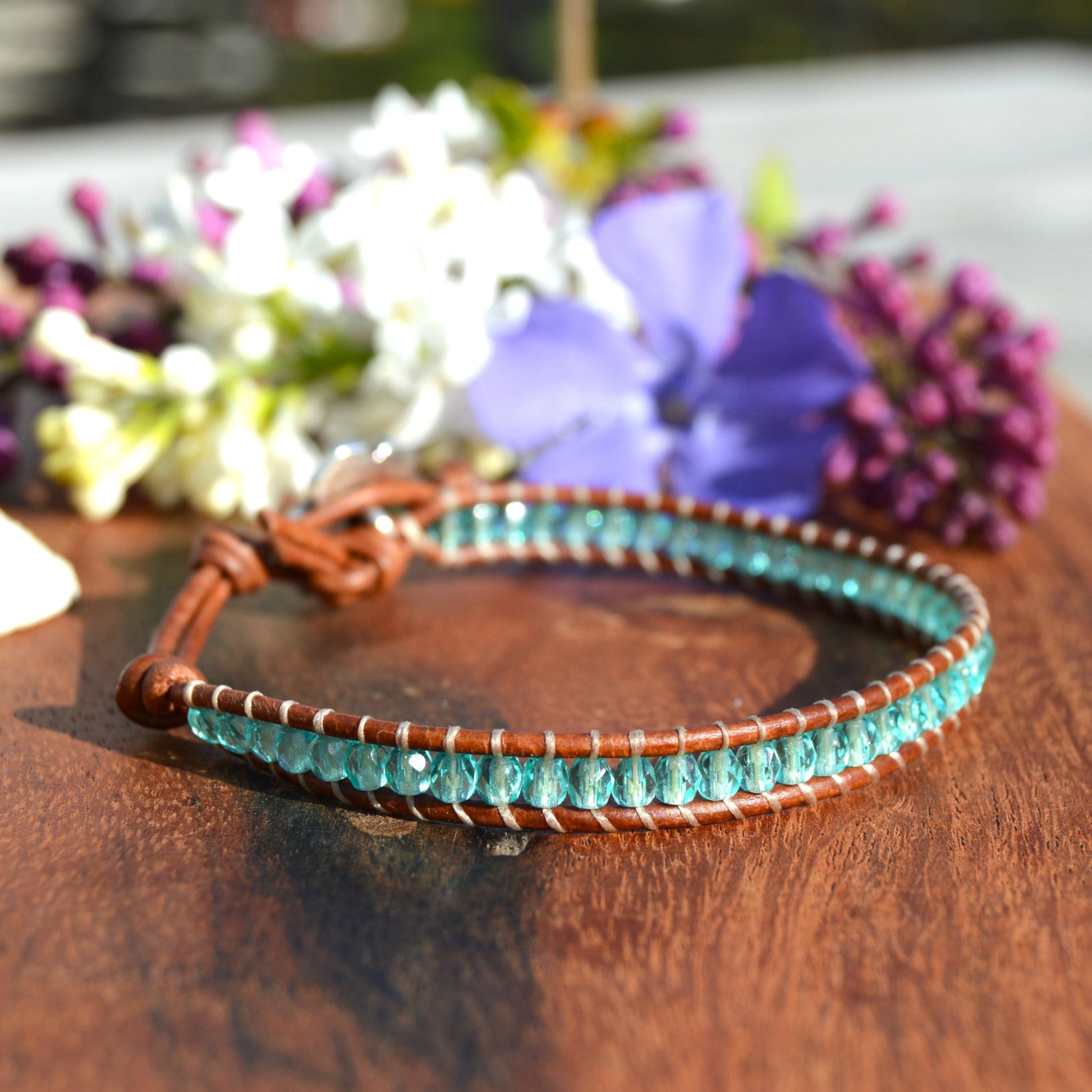 Leather wrap bracelet with Czech glass beads in light turquoise with flower button as a lock.