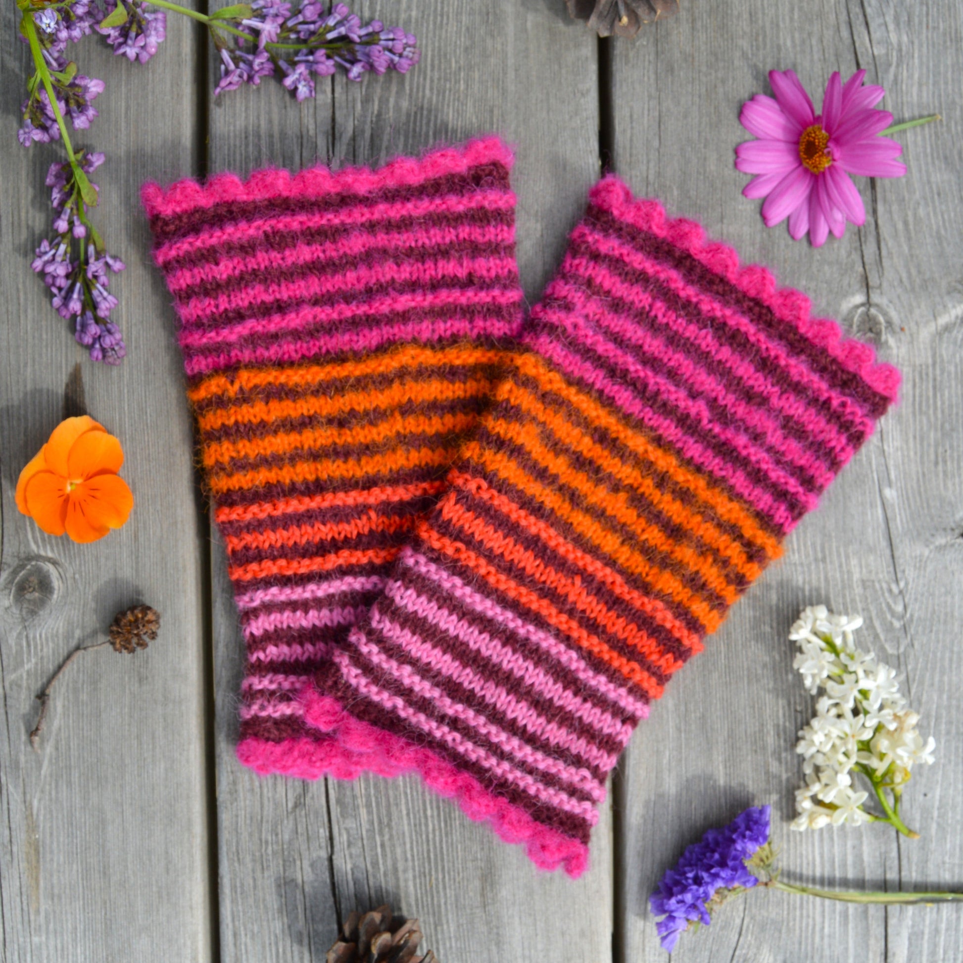 Knitted pulse warmers in alpaca wool in bordeuax colour with contrasting stripes in pink and orange tones.