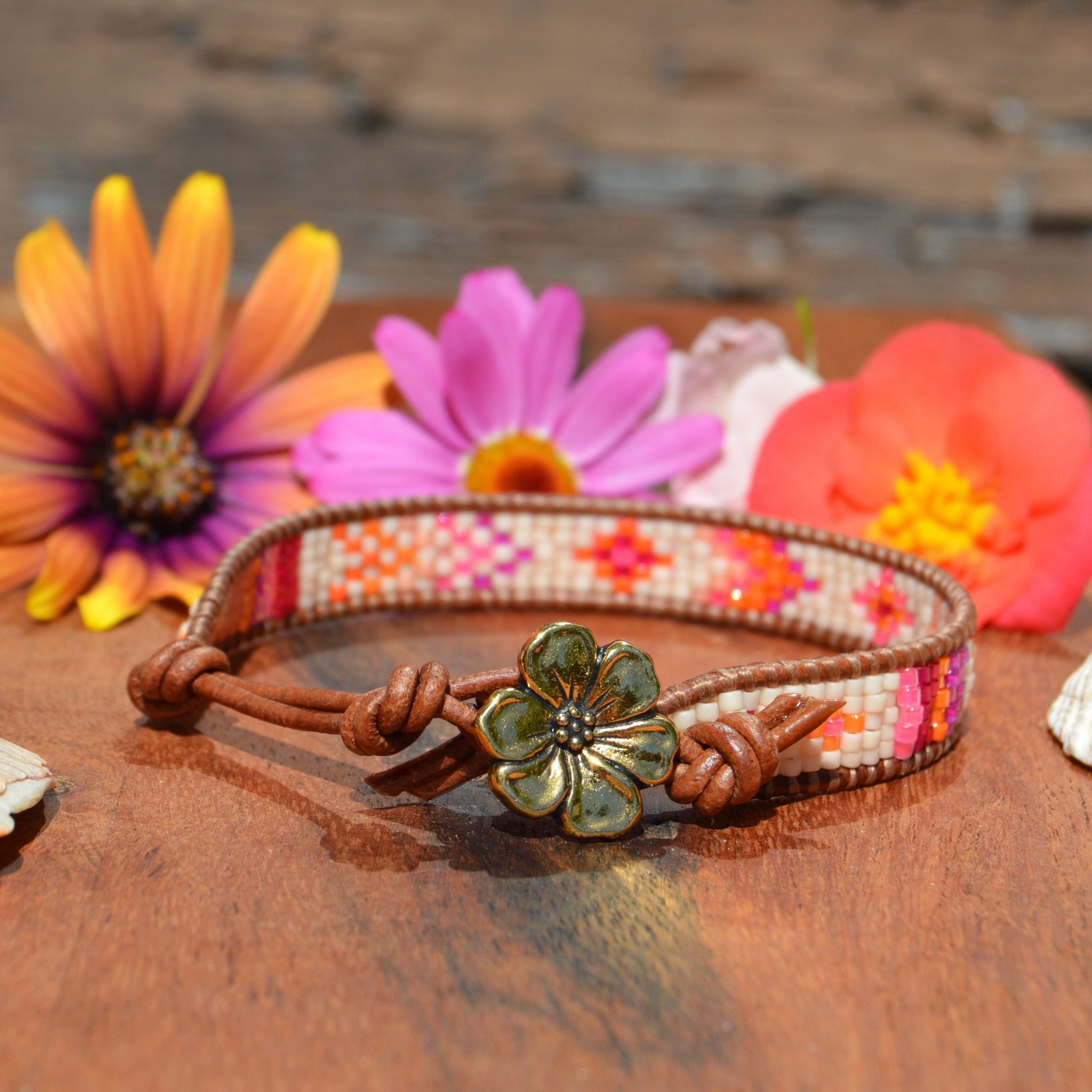 Woven bracelet made of Japanese seed beads of high quality wrapped on leather thread. Metal button in gold colour with flower design.