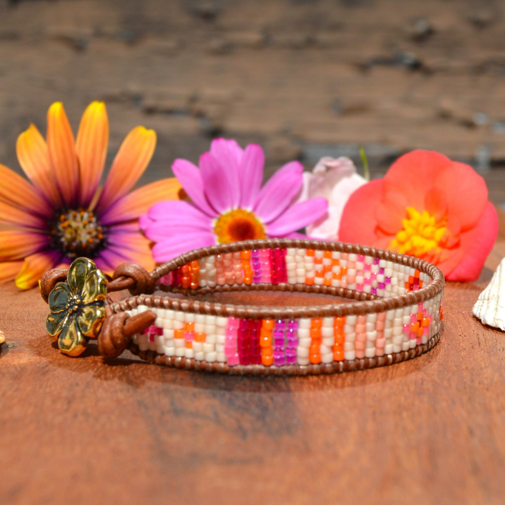 Woven bracelet made of Japanese seed beads of high quality wrapped on leather thread. Metal button in gold colour with flower design.