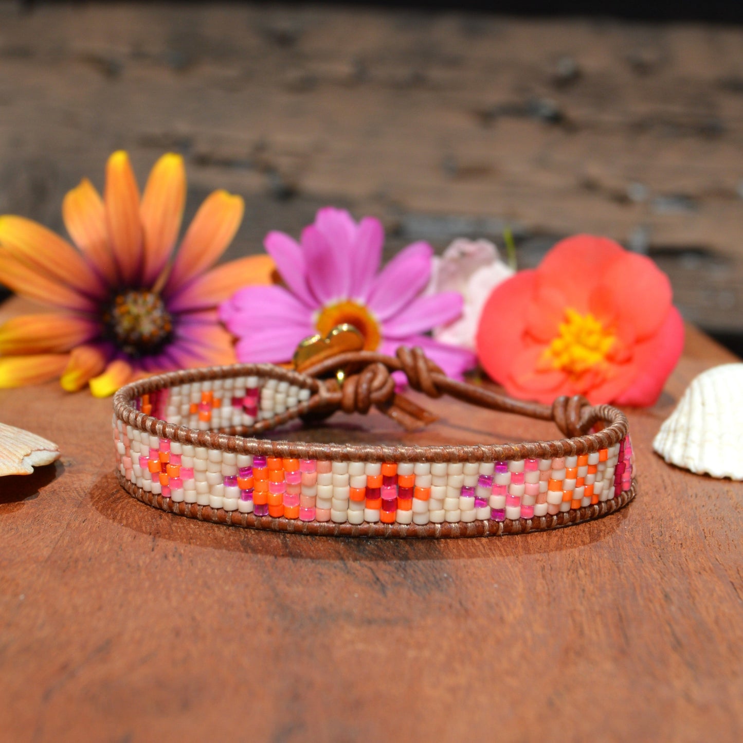 Woven bracelet made of Japanese seed beads of high quality wrapped on leather thread. Metal button in gold colour with flower design.