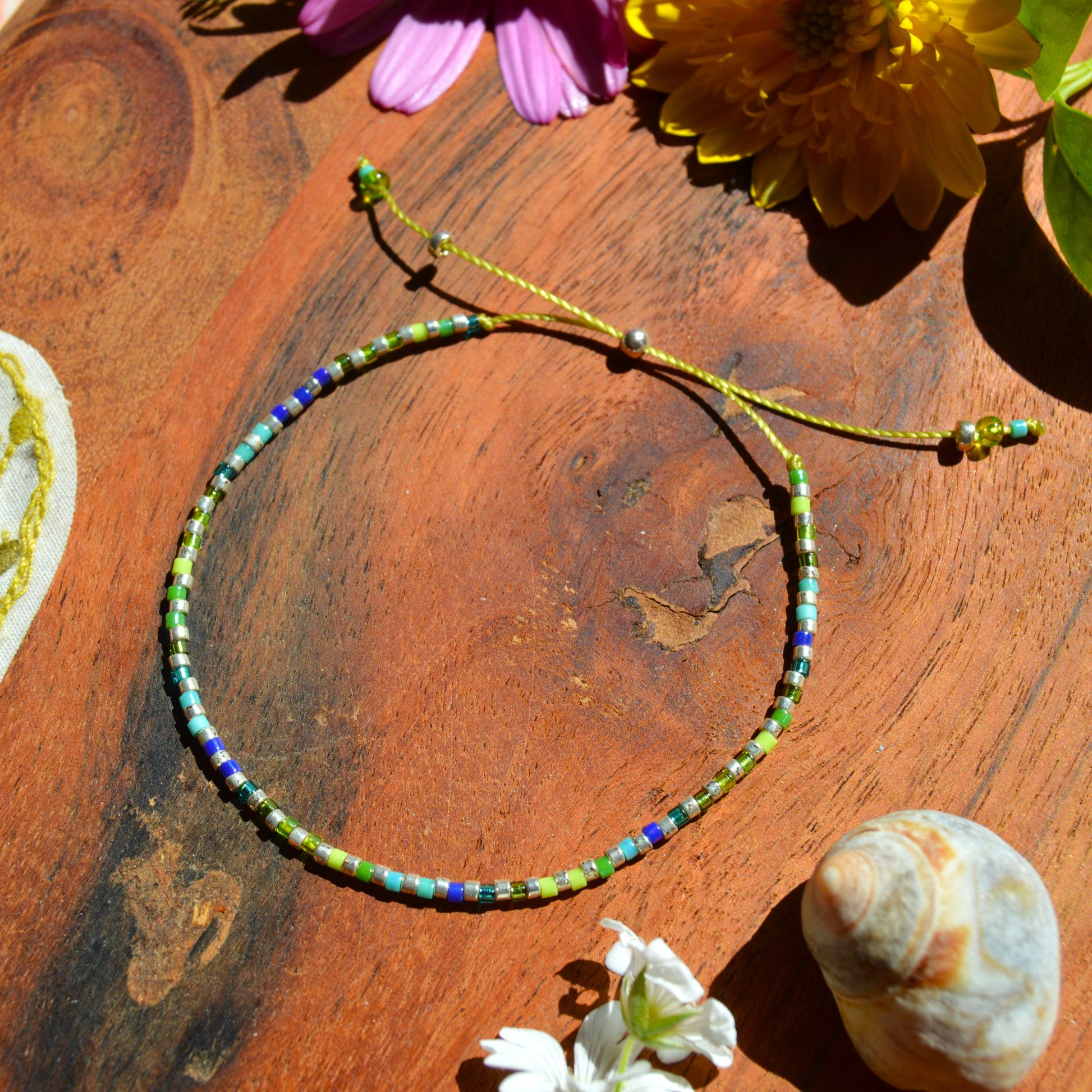 Adjustable, colourful beaded bracelet in green and blue tones.