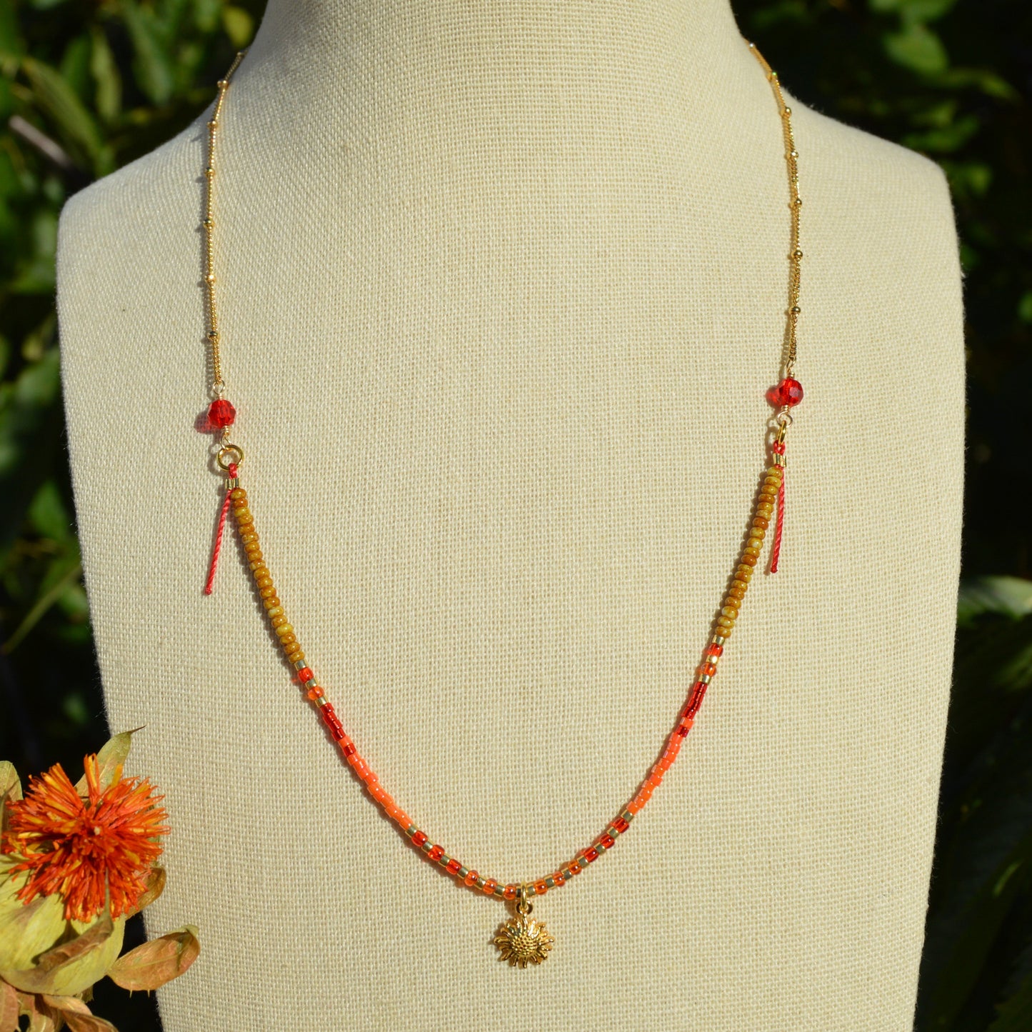 Bohemian, nature-inspired necklace in red and  orange shade attached to a delicate gold-plated sterling silver chain. With sun charm and red and orange faceted Czech glass crystals.