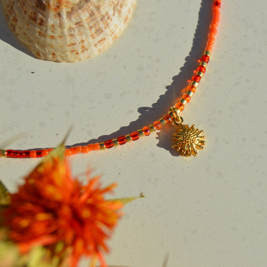 Bohemian, nature-inspired necklace in red and  orange shade attached to a delicate gold-plated sterling silver chain. With sun charm and red and orange faceted Czech glass crystals.