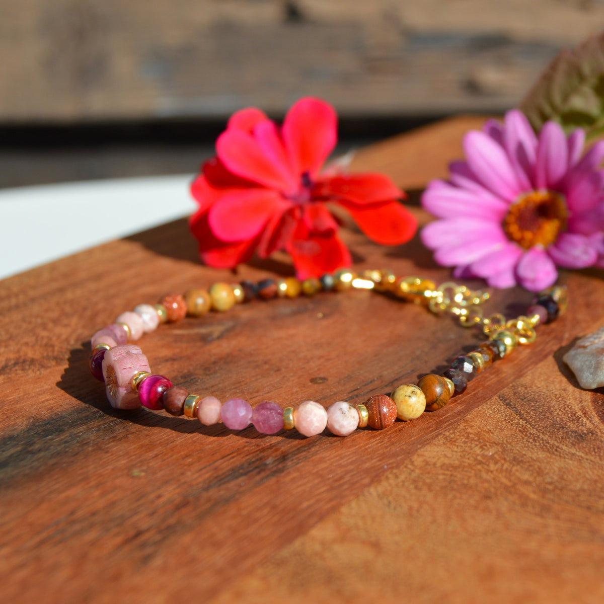 Gemstone bracelet in pink, beige, and brown town. Gold-plated sterling silver, and pink flower glass bead.