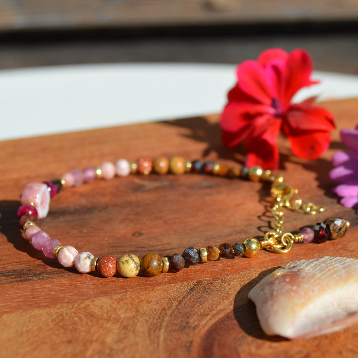 Gemstone bracelet in pink, beige, and brown town. Gold-plated sterling silver, and pink flower glass bead.