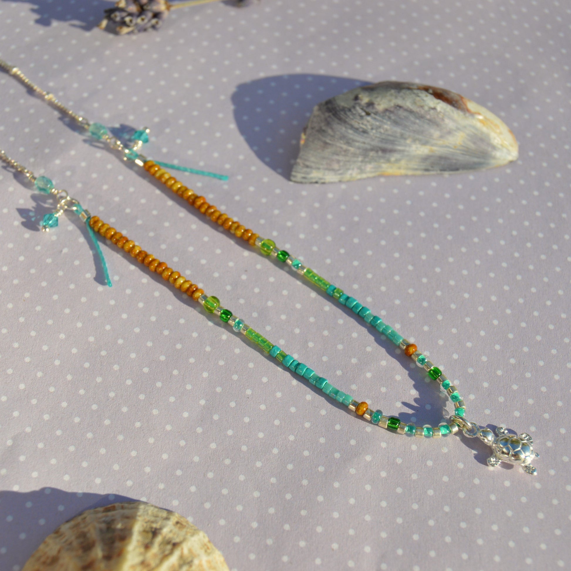 Beaded necklace with turtle charm in sterling silver. Closer to the Sea.