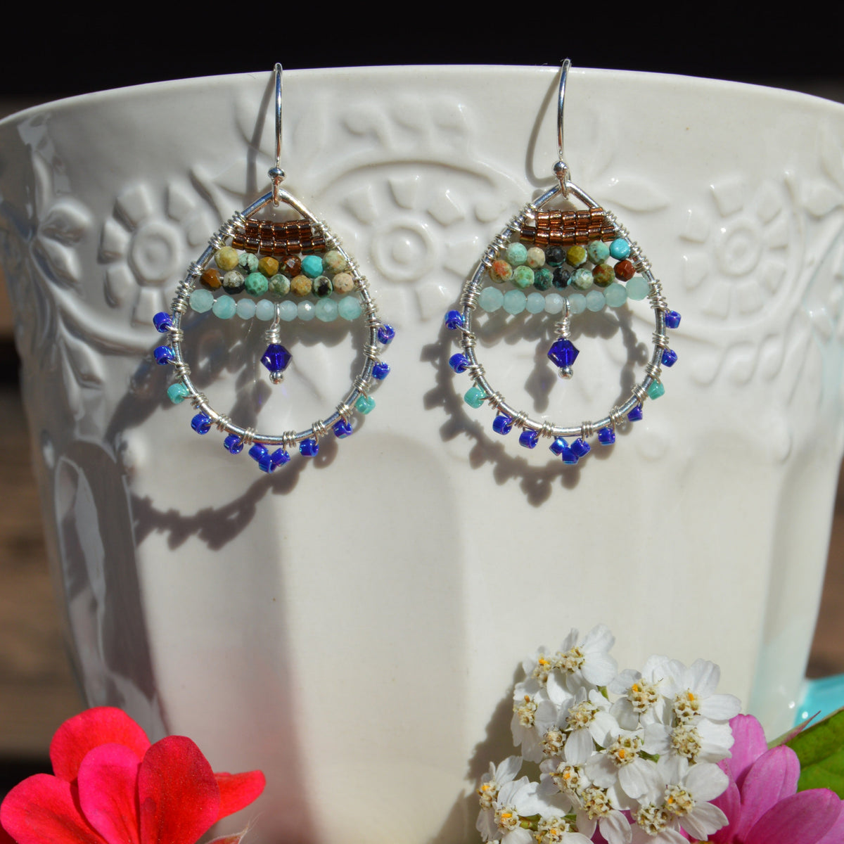 Wire wrap drop earrings in sterling silver, gemstones, and Japanese glass seed beads in blue tones.