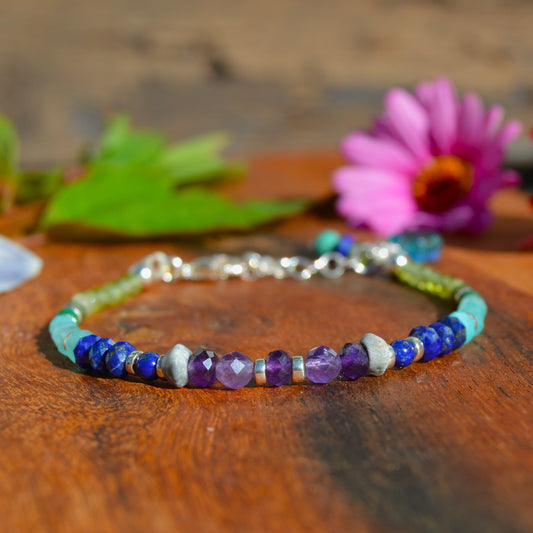Gemstone bracelet in sterling silver in violet, blue, and green tones.