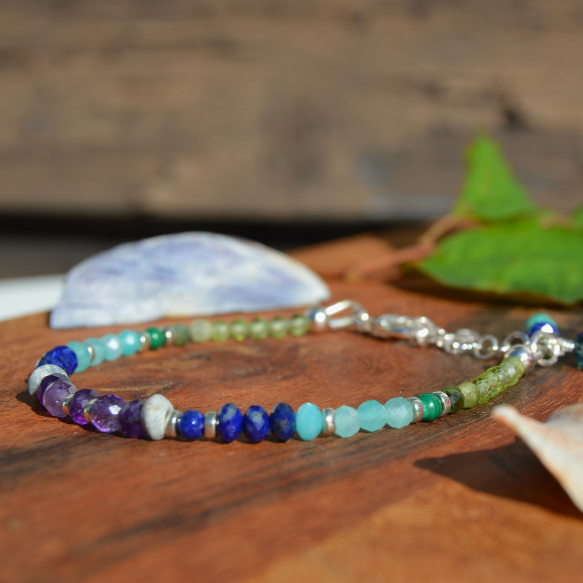 Gemstone bracelet in sterling silver in violet, blue, and green tones.