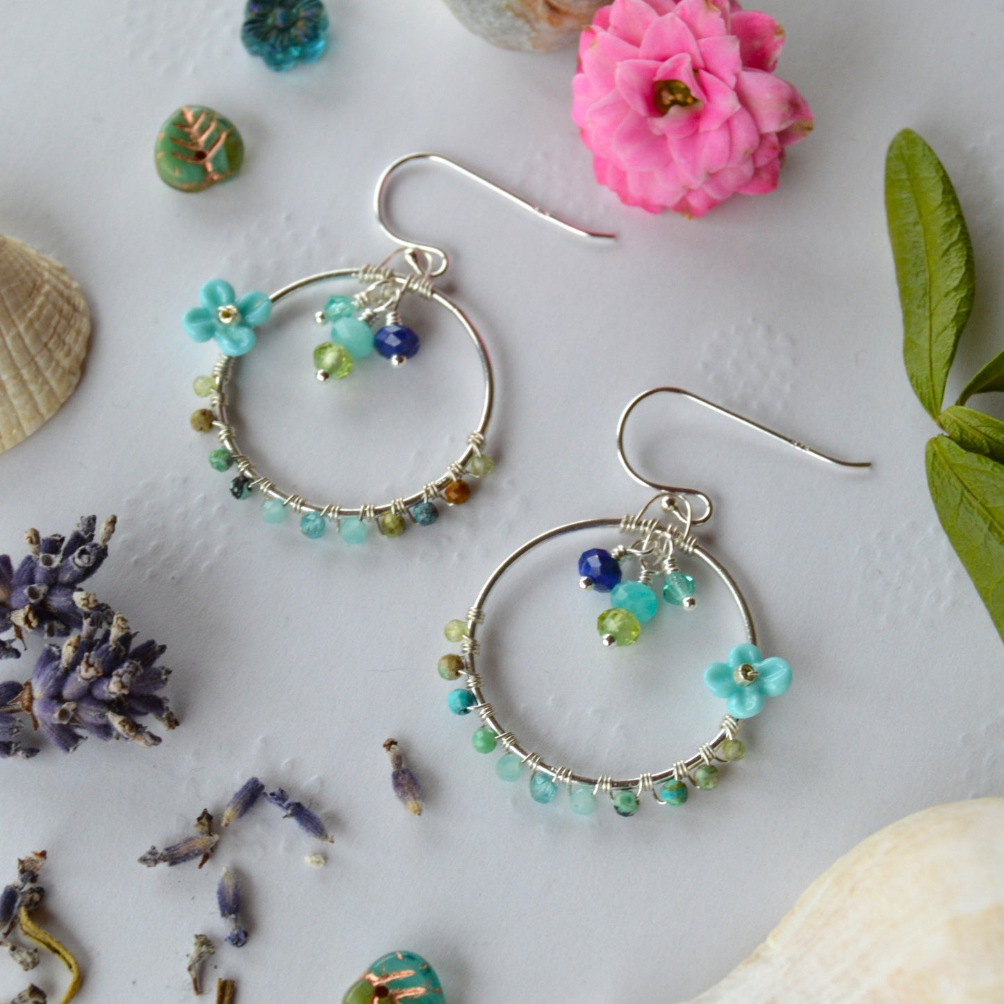 Hoop earrings in Sterling Silver wire-wrapped with gemstones, Czech glass faceted crystals, and lampwork beads crafted as flowers.