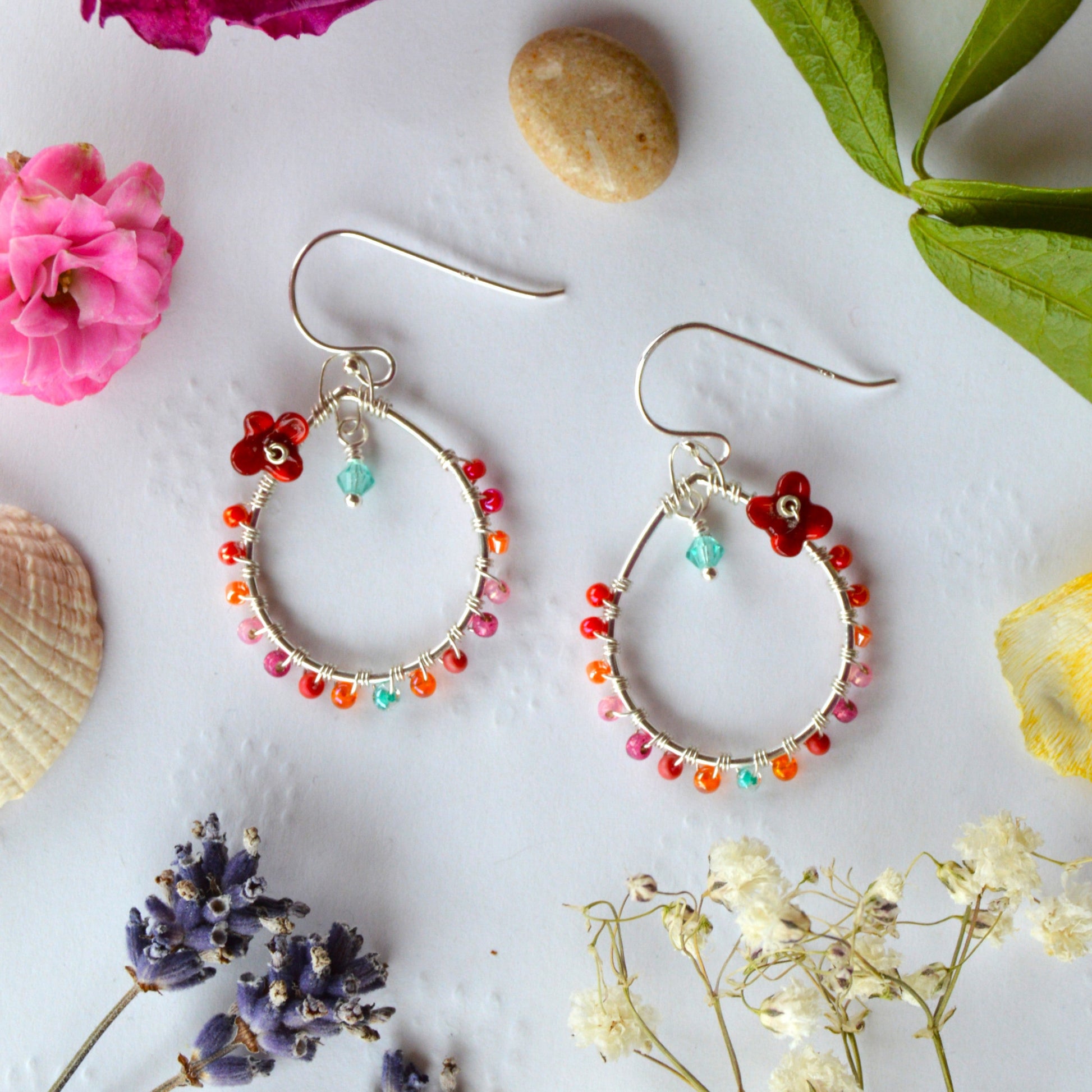 Delicate drop earrings in sterling silver wire-wrapped with Czech glass seed beads and lampwork beads crafted as flowers.