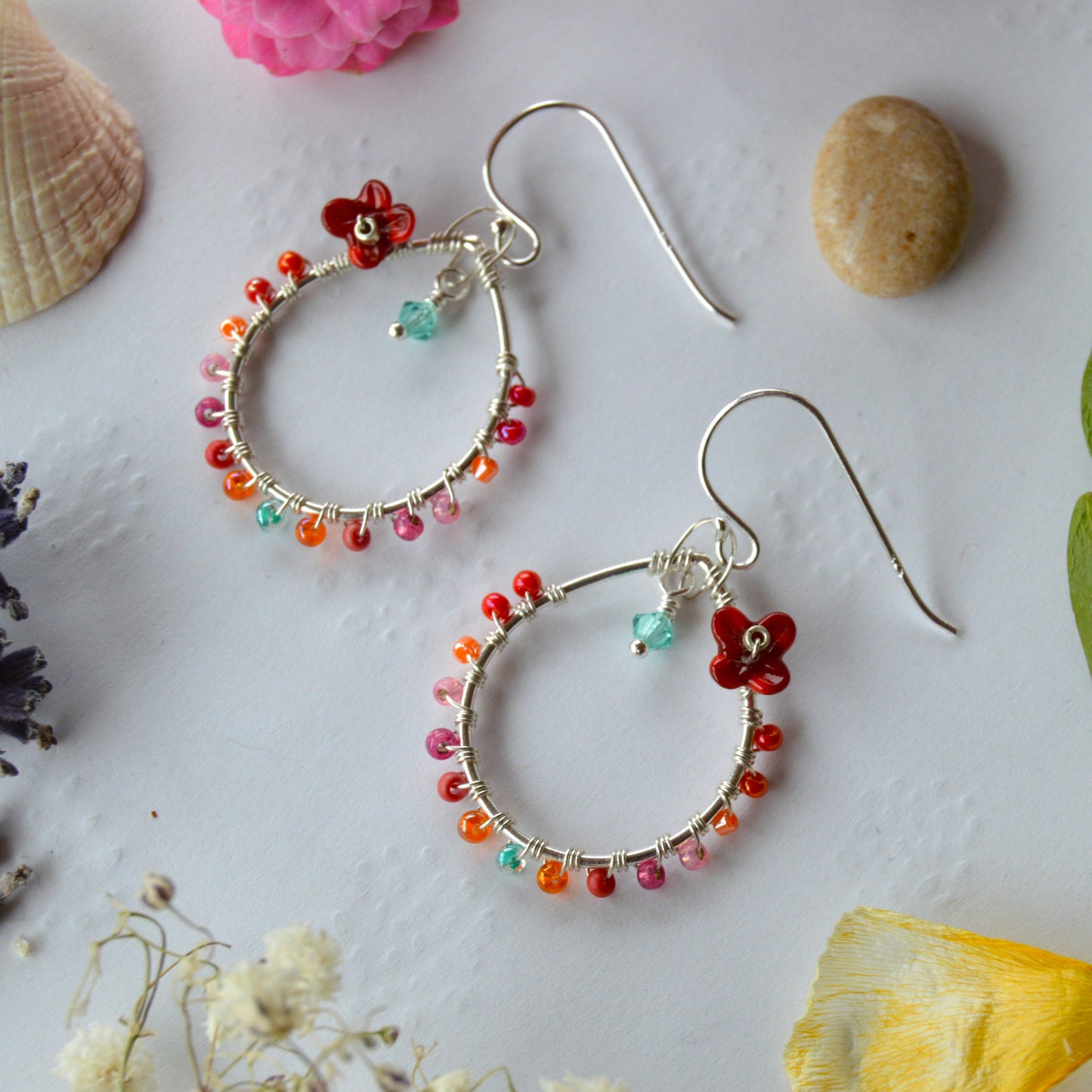 Delicate drop earrings in sterling silver wire-wrapped with Czech glass seed beads and lampwork beads crafted as flowers.