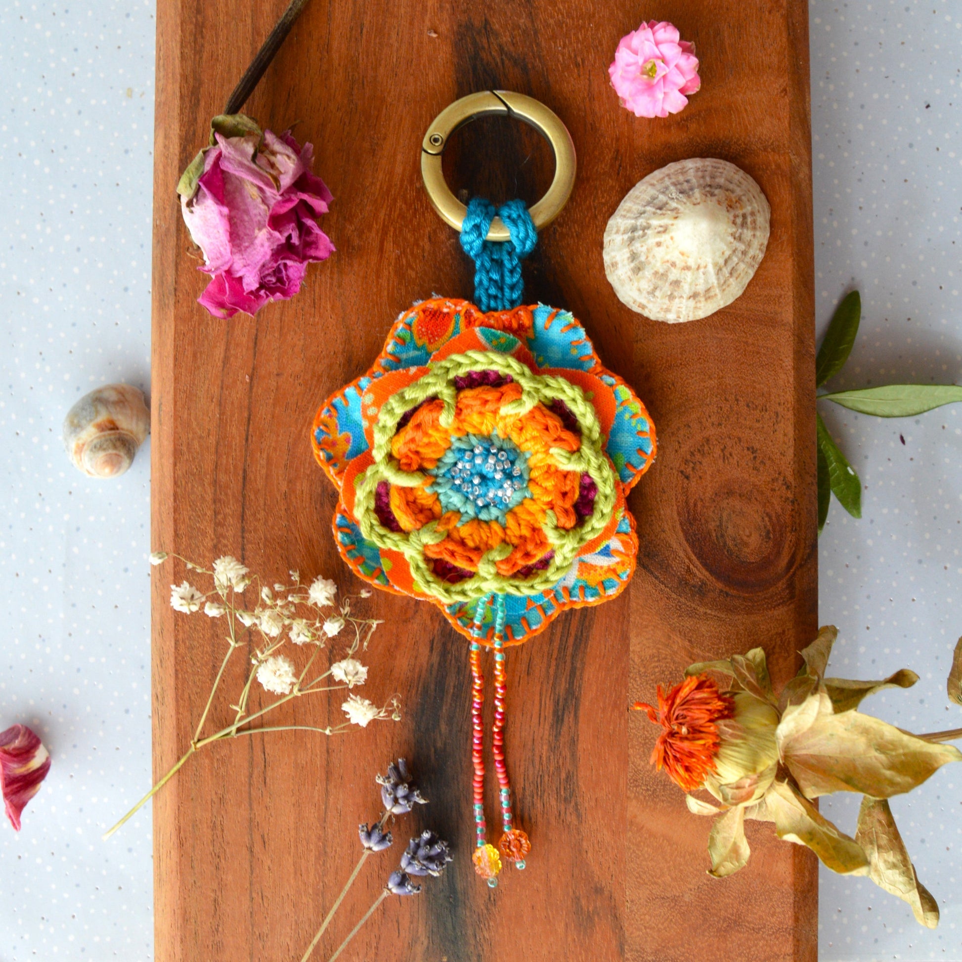 Handbag charm with crochet and fabric flowers decorated with seed beads.