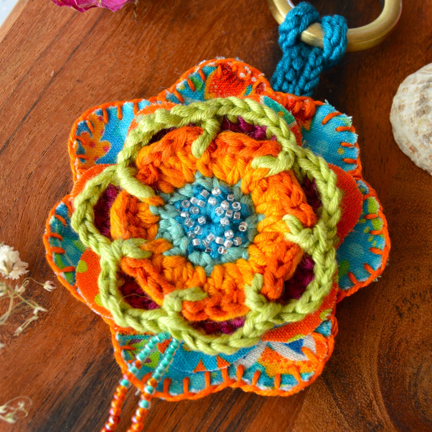 Handbag charm with crochet and fabric flowers decorated with seed beads.