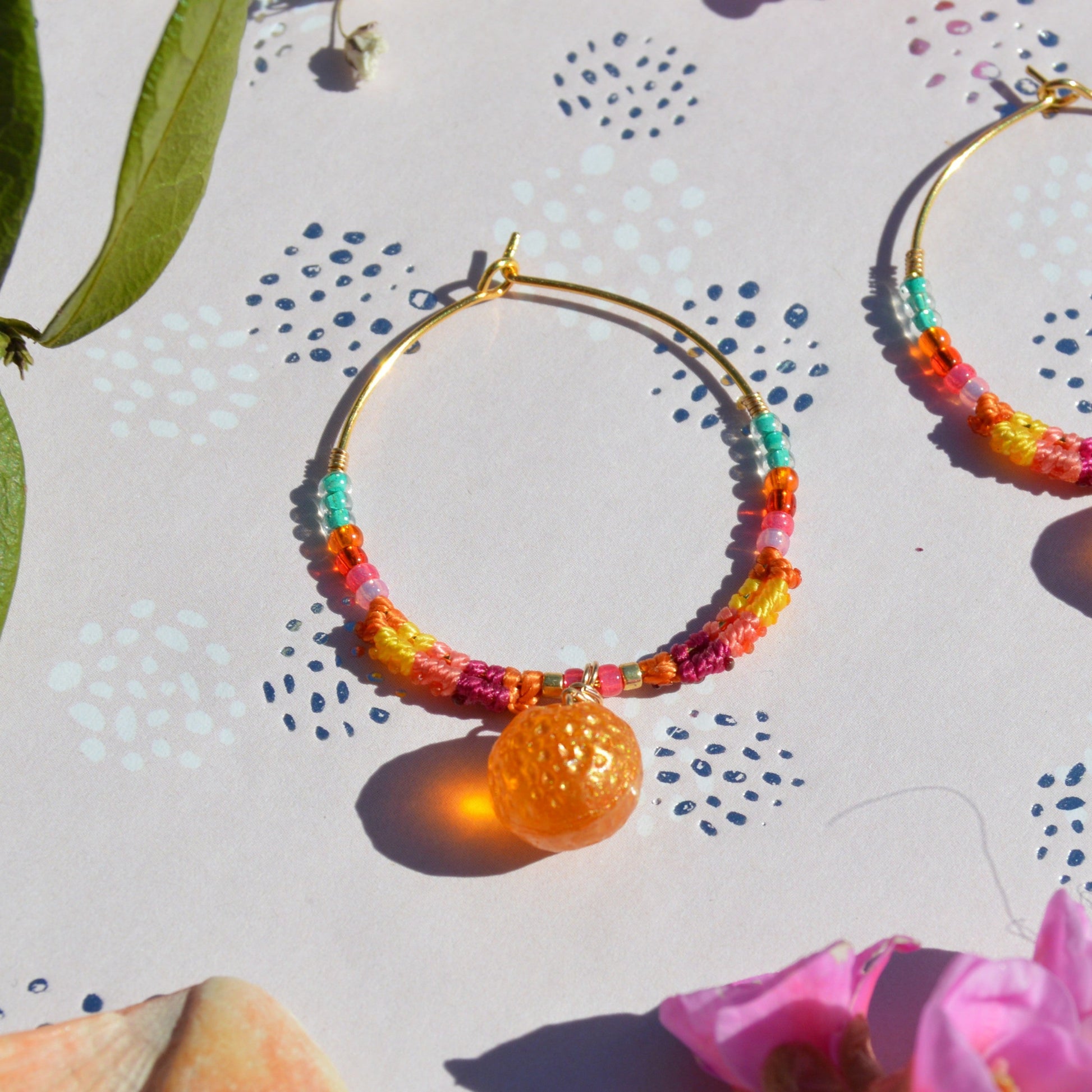 Colorful gold-plated sterling silver creoles decorated with micro macrame, Czech glass seed beads and Czech glass orange fruit bead in the center.