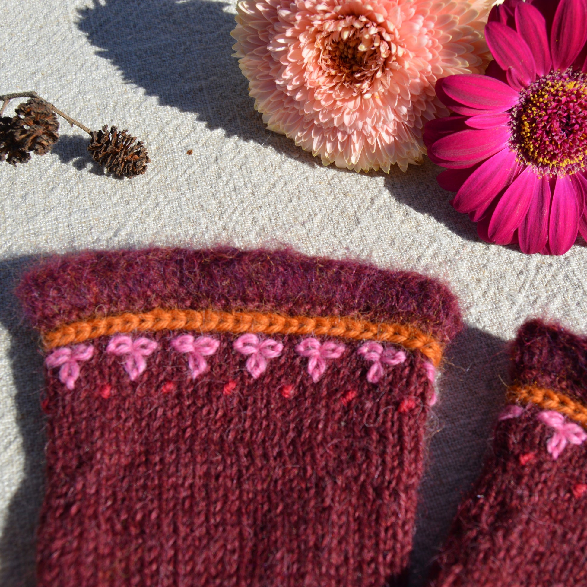 Knitted pulse warmers with crochet and embroidery details.