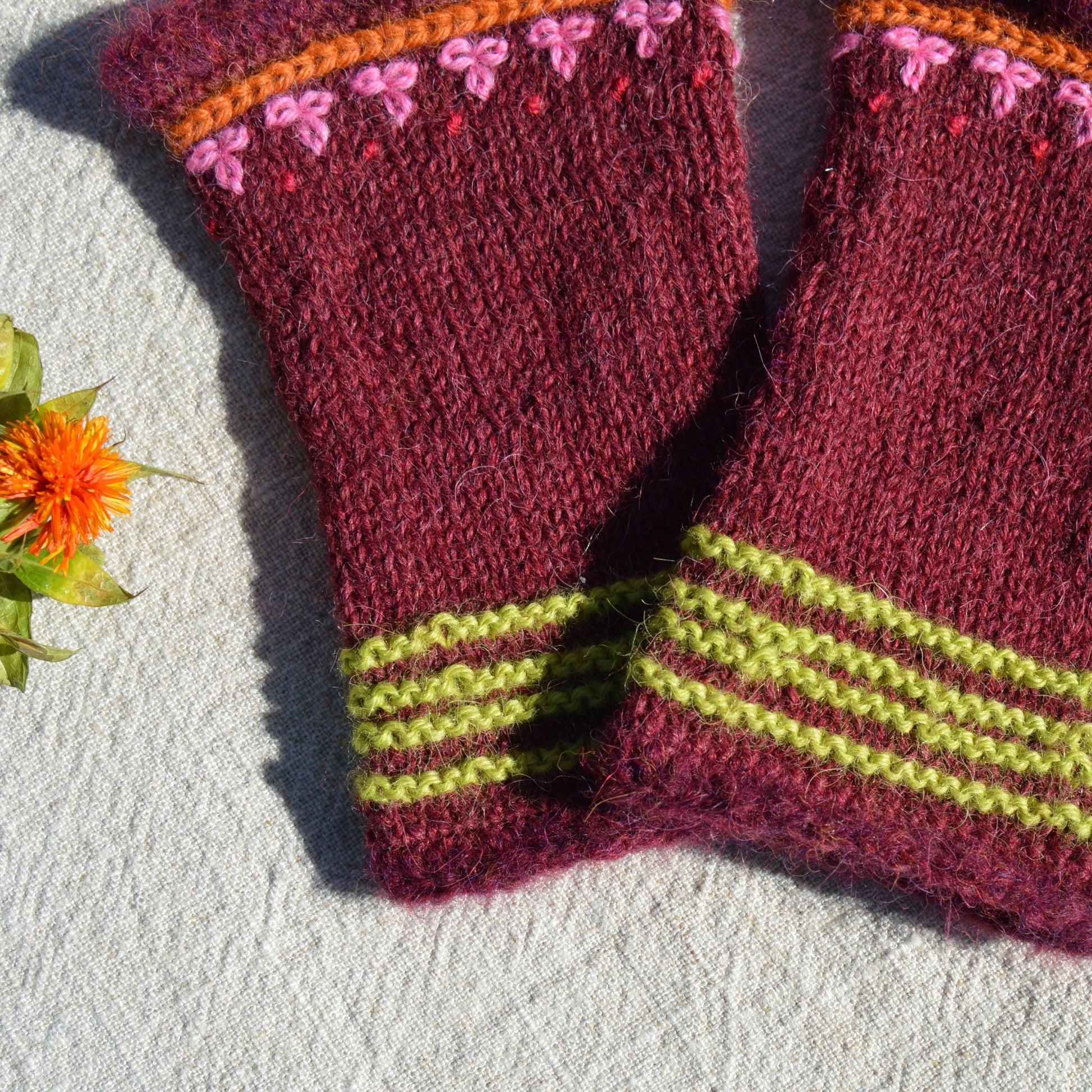 Knitted pulse warmers with crochet and embroidery details.