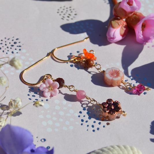 Gold-plated sterling silver earrings featuring Czech glass flowers, lampwork flowers, gemstones, and a bicone. Sold by piece.