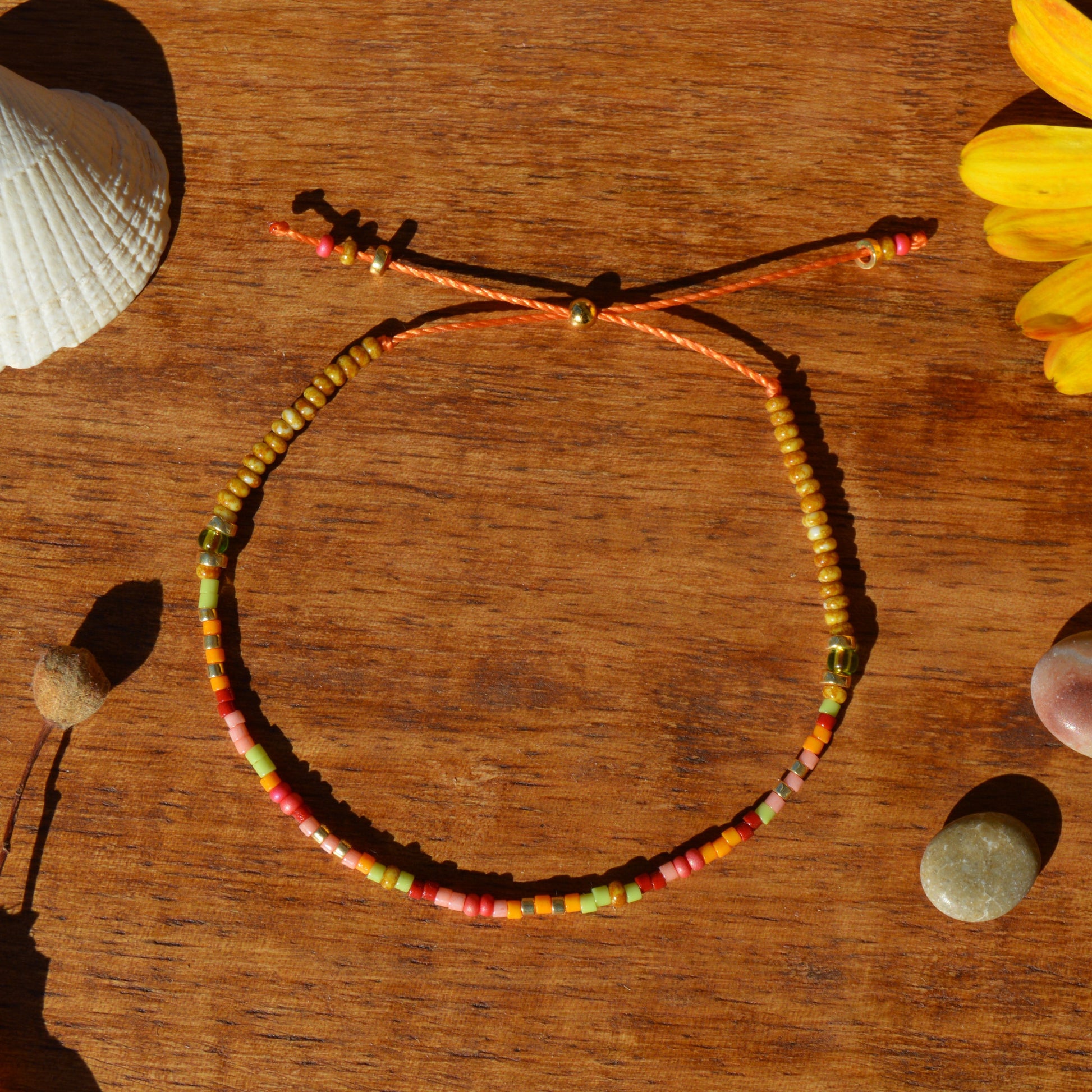 Adjustable, floral seed beads bracelet with silicone stopper bead on nylon cord.
