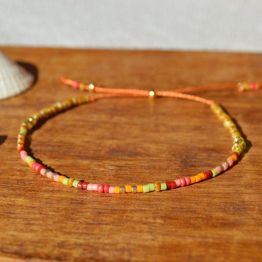 Adjustable, floral seed beads bracelet with silicone stopper bead on nylon cord.