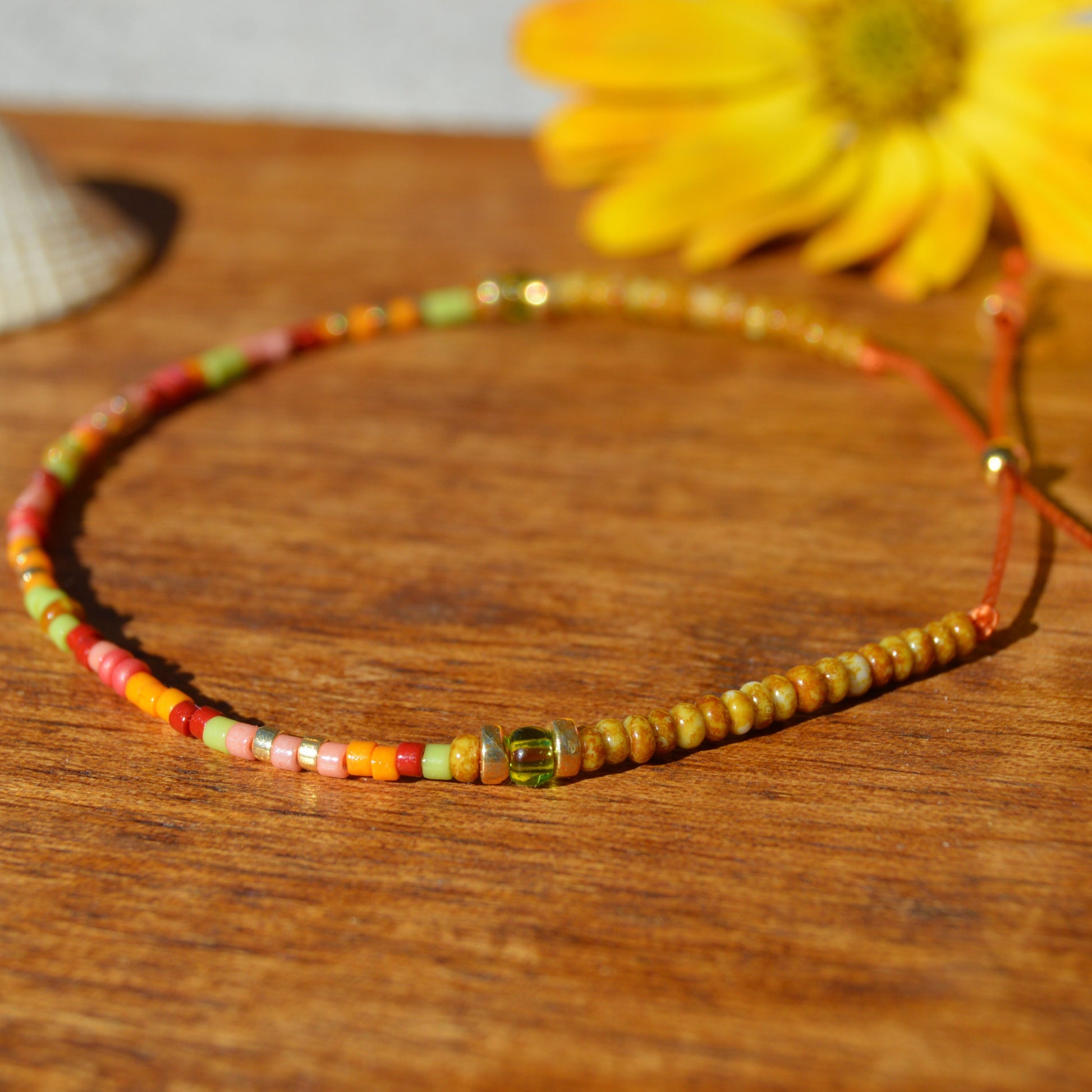 Adjustable, floral seed beads bracelet with silicone stopper bead on nylon cord.